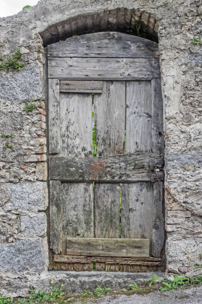 istock Old wooden door in a stone built wall 909258786