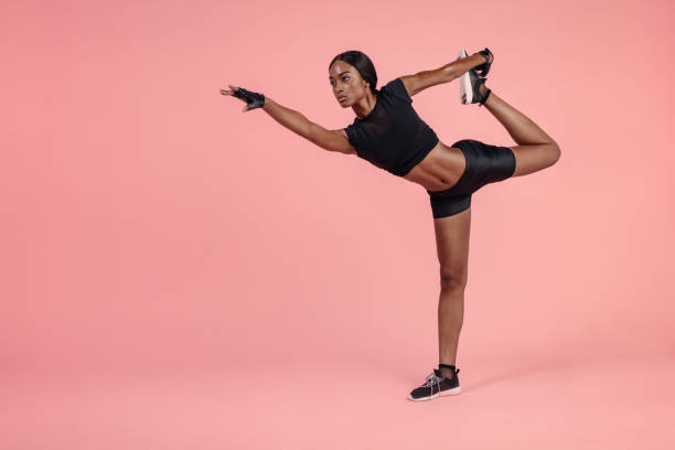 African woman practicing Natarajasana yoga pose