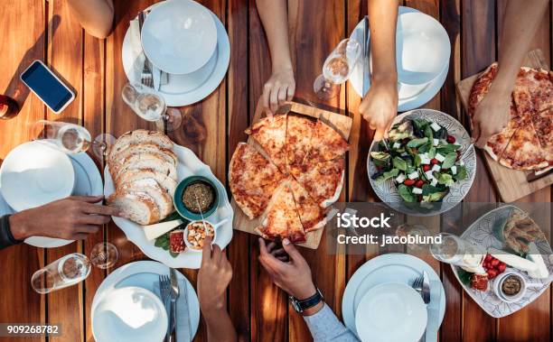 Amigos Con Pizza En La Fiesta Foto de stock y más banco de imágenes de Pizza - Pizza, Aire libre, Alimento