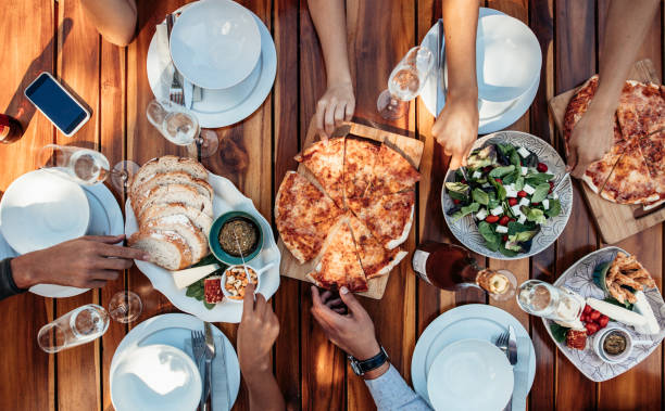друзья, имеющие пиццу на вечеринке - dinning table стоковые фото и изображения