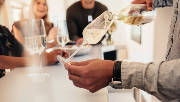 Man serving drinks to friends at new house