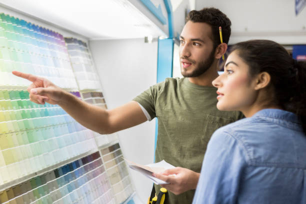istock Hardware store employee helps customer select paint color 909271582