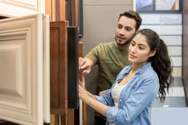 istock Couple look at cabinet samples in hardware store 909271586