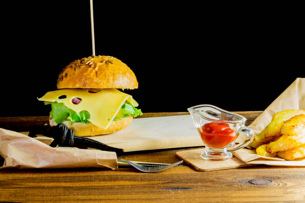 istock fresh tasty burger's on black background 909283426