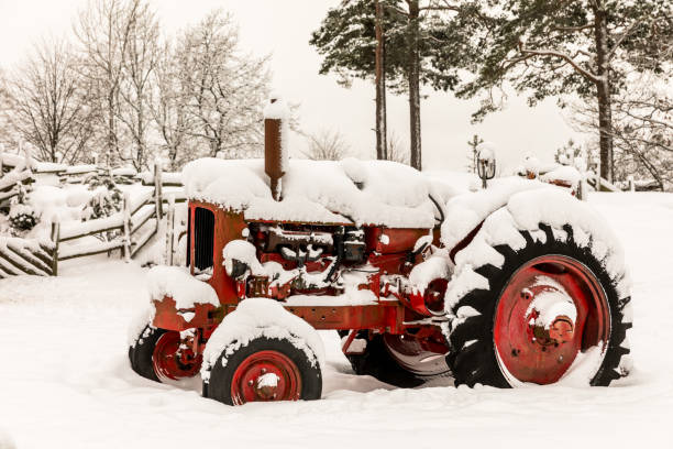 istock Old red tractor covered in snow 909288498