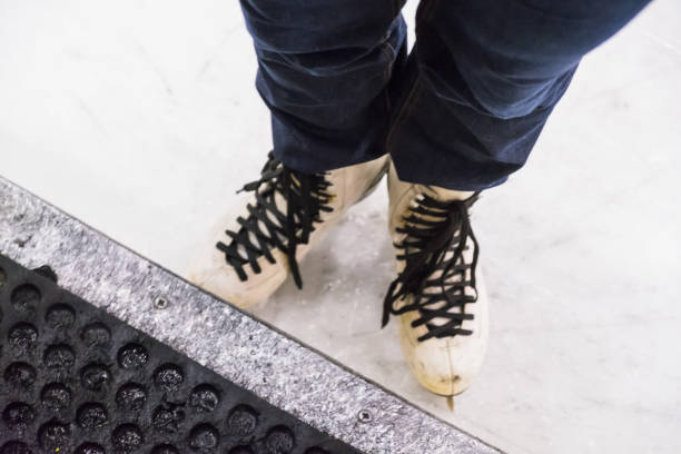 istock Female feet rolling on skates on the ice rink 909294438