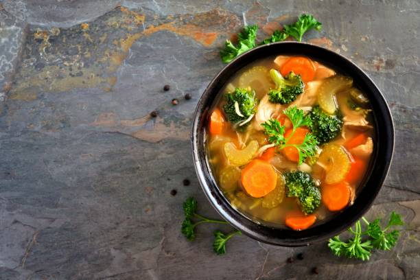 istock Homemade chicken vegetable soup, overhead on slate 909299474