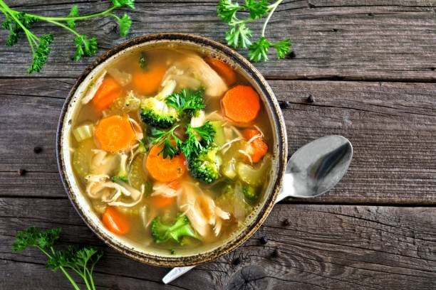 istock Homemade chicken vegetable soup, top view on rustic wood 909299960