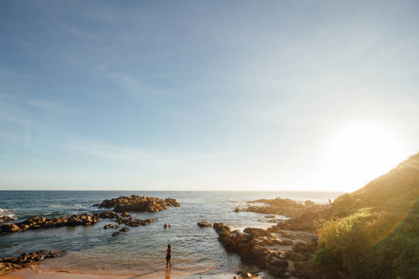 サルヴァドール ・ デ ・ バイーア州、ブラジルの夕日の中に岩の間ビーチで女性 - salvador bahia state travel women ストックフォトと画像