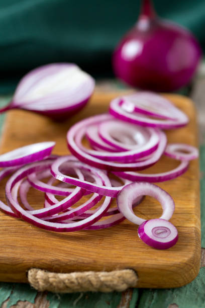 red onion on cutting board - spanish onion fotos imagens e fotografias de stock