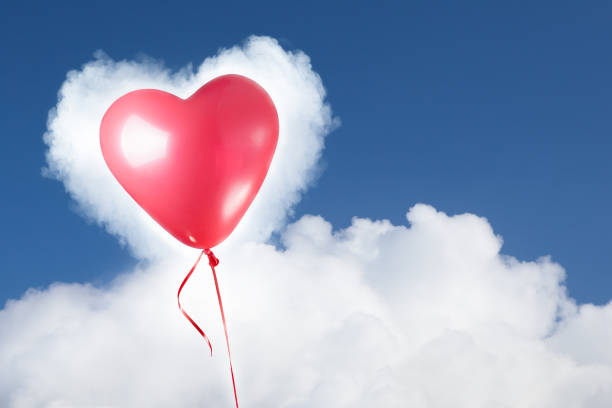 istock festive red heart balloon on blue sky 909303930