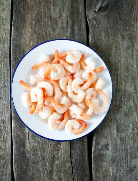 istock frozen shrimps on wooden surface 909306112