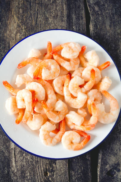 istock frozen shrimps on wooden surface 909306118