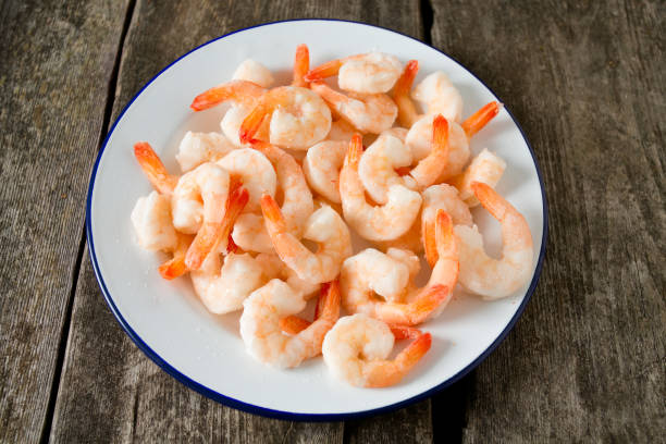 istock frozen shrimps on wooden surface 909306334