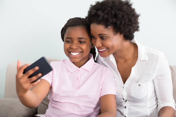 istock Mother And Daughter Taking Selfie 909307128