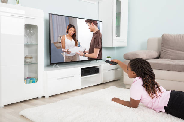 istock Girl Changing The Channel With Remote Control 909307144