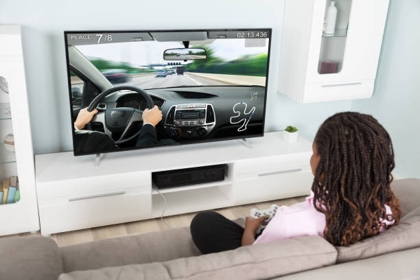 istock Girl Playing Video Racing Car Game 909307194