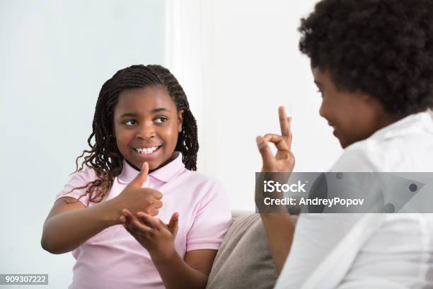 Deaf Mother Talking Sign Language With Her Daughter Stock Photo - Download Image Now