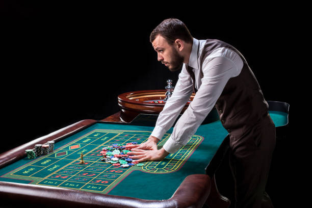 croupier detrás de tabla en un casino de juego - roulette table fotografías e imágenes de stock