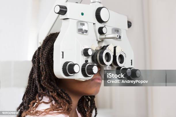 Girl Doing Eye Test Stock Photo - Download Image Now - Eye Exam, Child, Afro Hairstyle