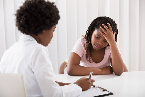 istock Female Doctor Comforting Depressed Patient 909309936