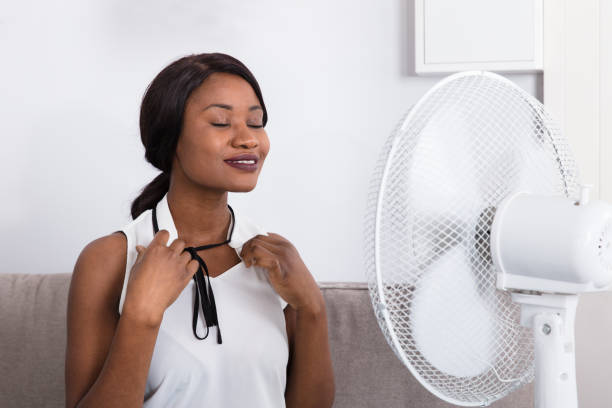 istock Woman Cooling Herself In Front Of Fan 909313564