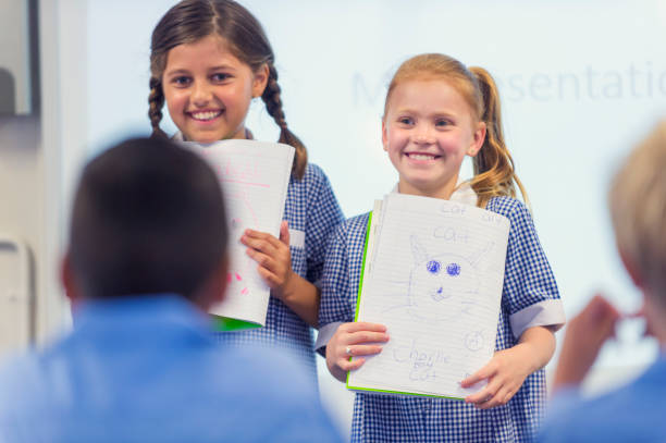 Schoolgirls giving a presentation in school uniform.