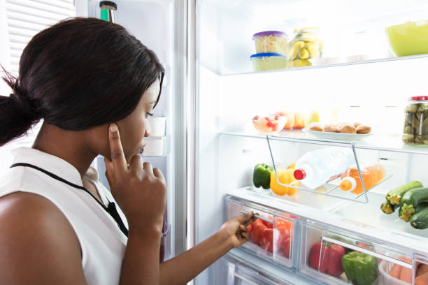 istock Young Woman Looking In Fridge 909313962