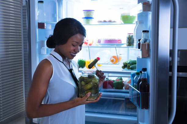 istock Young Woman Eating Pickle 909313998