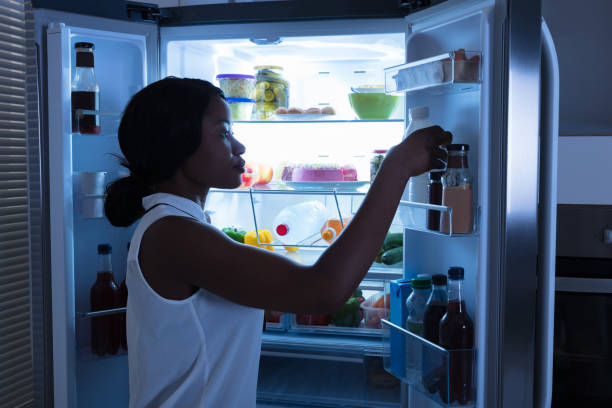 istock Woman Taking Out Bottle From Refrigerator 909314002