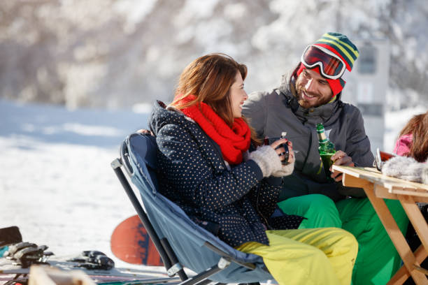 istock Skiers couple drinking and talking in cafe on skiing 909314034