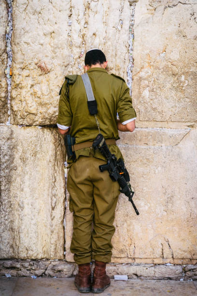 Israeli Defense Force soldier prays at Judaism's holiest site, the Western Wall Jerusalem, Israel - February 26, 2017: Israeli Defense Force soldier prays at Judaism's holiest site, the Western Wall soldier on the wall stock pictures, royalty-free photos & images