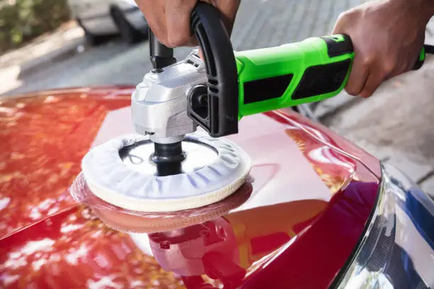 Close-up Of Person Hands Polishing Car With Orbital Polisher