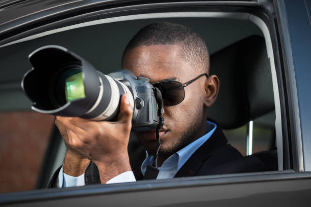 istock Detective Sitting Inside Car Photographing 909314630