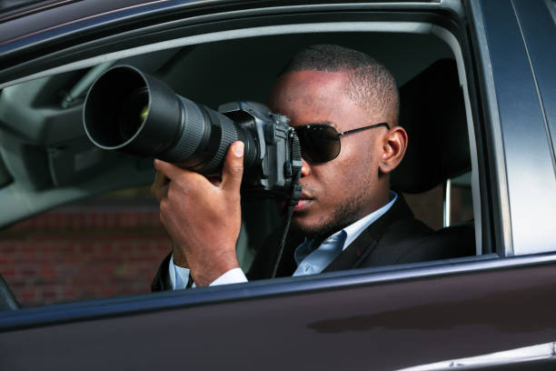 istock Detective Sitting Inside Car Photographing 909314644