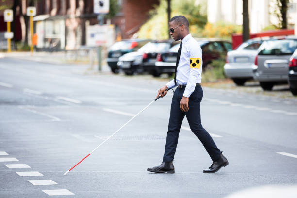 istock Blind Man Wearing Armband Walking With Stick 909314654