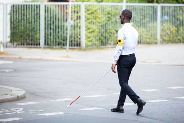 istock Blind Man Wearing Armband Walking With Stick 909314678
