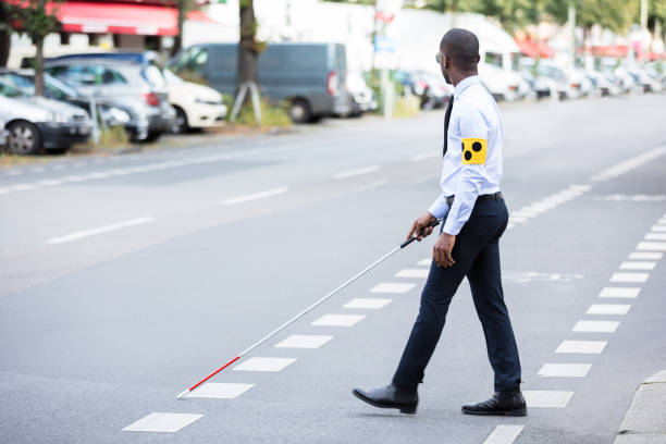 istock Blind Man Wearing Armband Walking With Stick 909314682