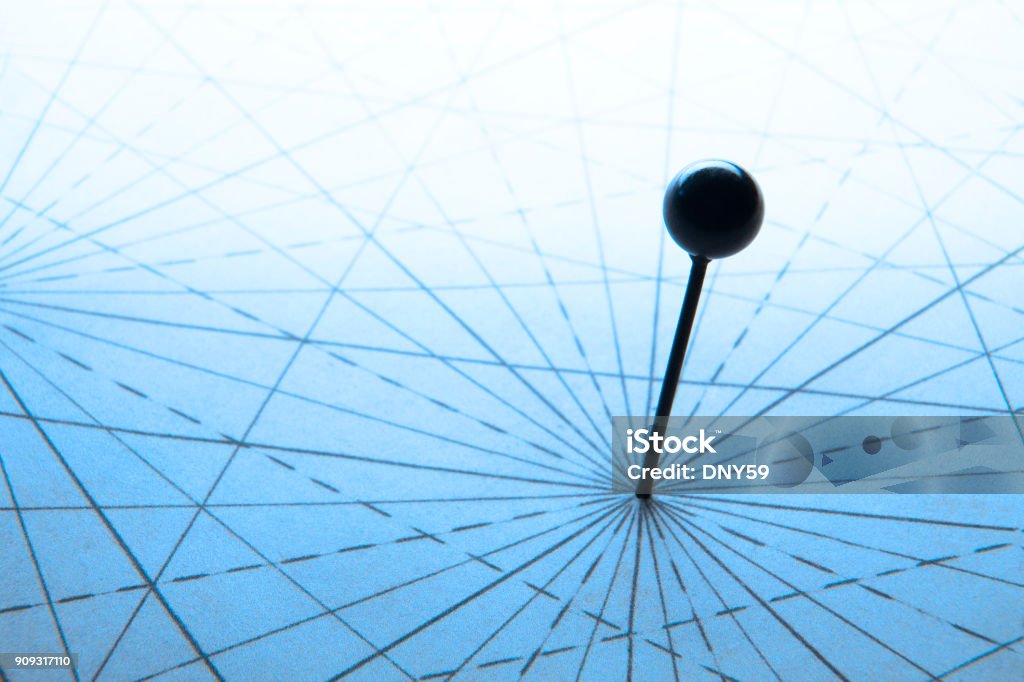 Close-up Of An Old Push Pin On An Antique A push pin sits at the intersection of navigational lines on an old map. Accuracy Stock Photo