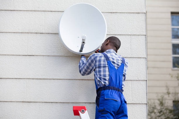 istock Man In Uniform Fitting TV Satellite Dish 909317224