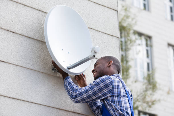 istock Man In Uniform Fitting TV Satellite Dish 909317244
