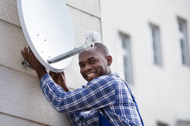 istock Man In Uniform Fitting TV Satellite Dish 909317246