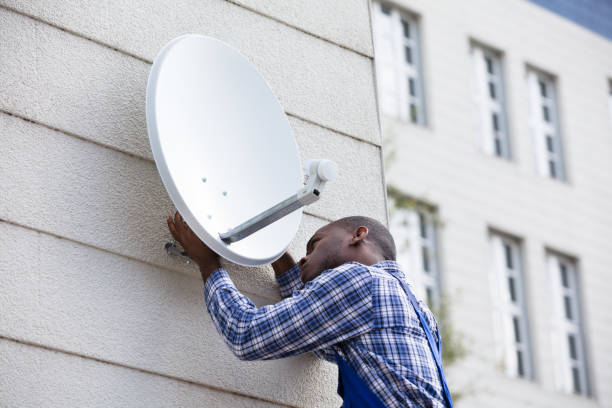 istock Man In Uniform Fitting TV Satellite Dish 909317256
