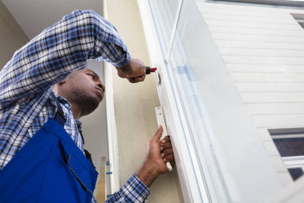 istock Handyman In Uniform Fixing Glass Window 909317258