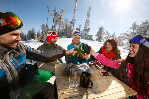Skiers group toasts with drinks in cafe on ski terrain Happy skiers group toasts with drinks in cafe on ski terrain snowboarding snowboard women snow stock pictures, royalty-free photos & images