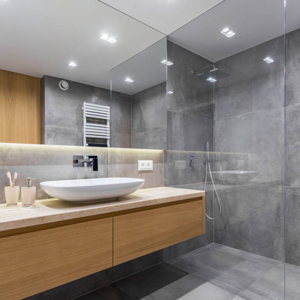 istock Gray bathroom with long countertop 909324160
