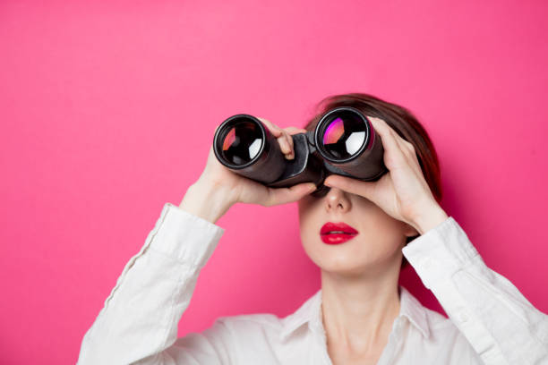 Portrait of young  businesswoman with binoculars stock photo