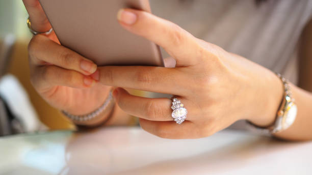 gros plan des mains de femme à l’aide d’un smartphone. - ring jewelry diamond luxury photos et images de collection