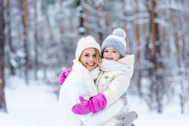 istock daughter and mother hugging each other in winter forest 909332514