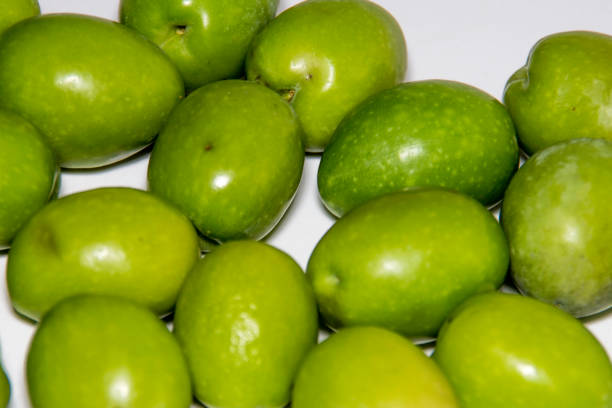 istock Green olives ready to eat in white background. 909332780